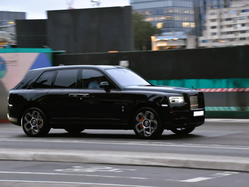 Rolls-Royce Cullinan di jalan kota, tampak depan tiga perempat — foto ilustrasi model