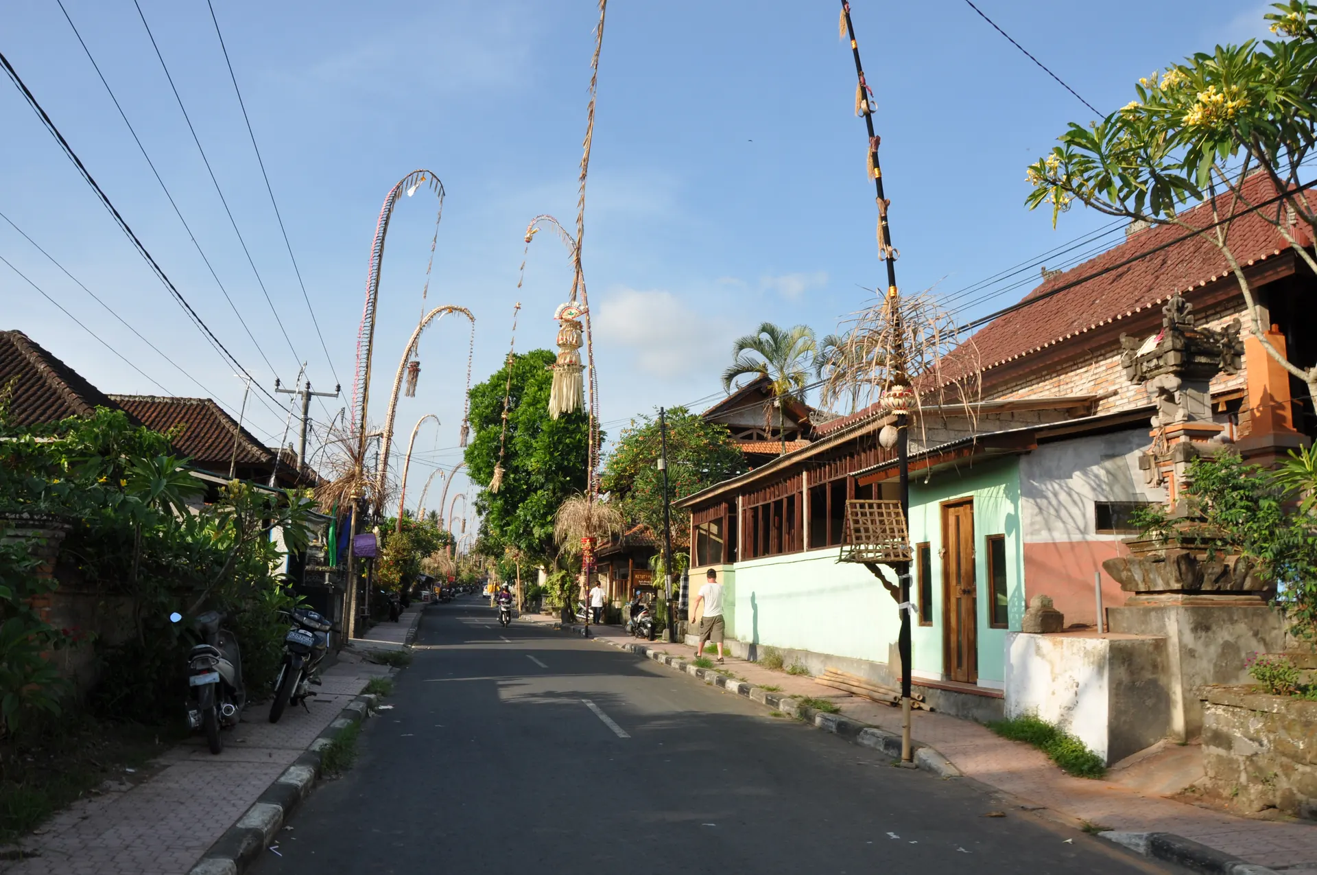 Penjor berjajar di jalan desa saat perayaan di Bali