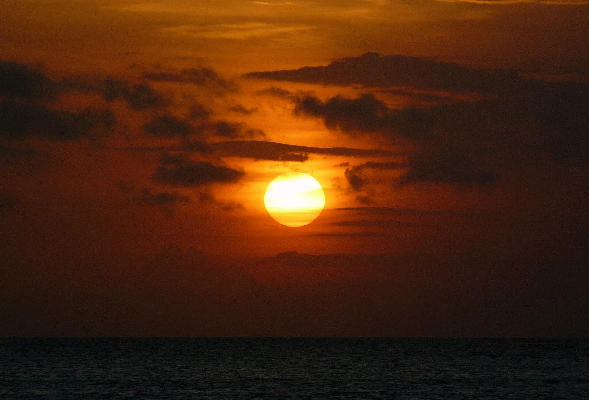 Matahari terbenam berwarna jingga di Pantai Jimbaran, Bali